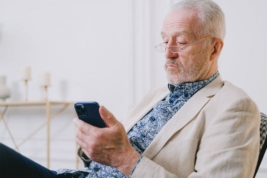 Uomo anziano che consulta informazioni da smartphone, forse su integratori per la libido.